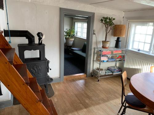 sala de estar con estufa de leña y mesa en Timberframe house near Marstal Harbour, en Marstal