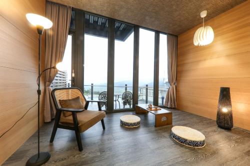 a living room with a chair and large windows at 玉蘭函館民宿Yulan Hokodate in Datong