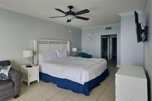 Schlafzimmer mit einem Bett, einem Deckenventilator und einem Sofa in der Unterkunft Majestic Beach Towers II 1902 in Panama City Beach