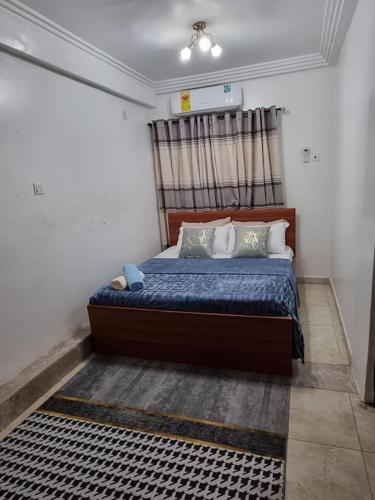 a bedroom with a bed with blue sheets and pillows at Natako Apartment in Apenkwa