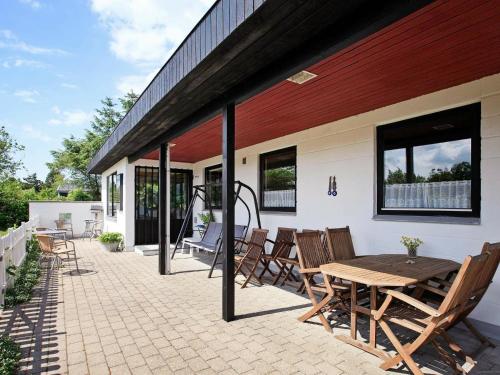 a patio with a wooden table and chairs at 8 person holiday home in Struer in Humlum