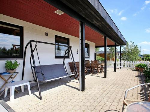 een veranda met een schommel en een patio bij 8 person holiday home in Struer in Humlum