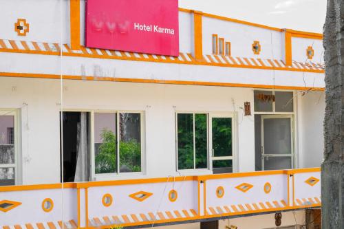a white and orange building with windows at Karma Hostel in Khajurāho