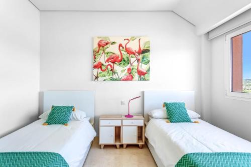 Un dormitorio con dos camas y un cuadro en la pared. en Ribera del Marlin Atico/Penthouse, en Sotogrande
