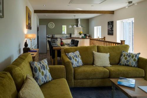 een woonkamer met een bank en een keuken bij Church House Barn Lake District & Solway Coast with Solway Firth views in Silloth