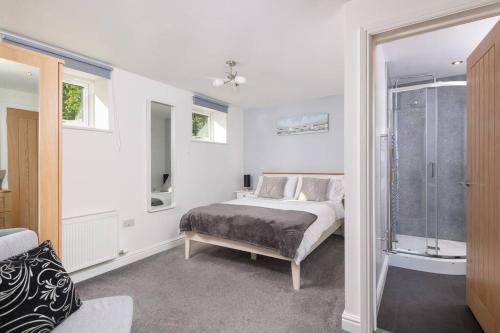 Habitación blanca con cama y ventana en Church House Barn Lake District & Solway Coast with Solway Firth views, en Silloth