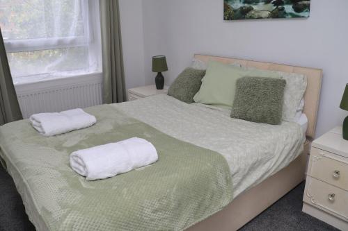 a bedroom with a bed with towels on it at Superb 3 Bedroom flat in Stafford in Stafford