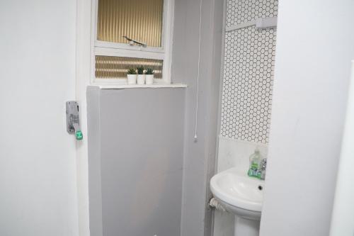 Baño blanco con lavabo y aseo en Superb 3 Bedroom flat in Stafford en Stafford