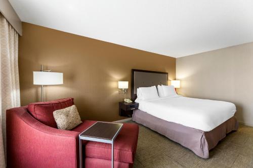 Habitación de hotel con cama y silla roja en Comfort Inn, Cleveland South - Richfield, en Richfield