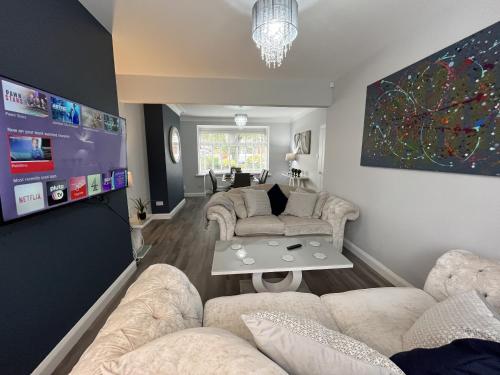 een woonkamer met banken en een flatscreen-tv bij Modern 3-bed stay-away-home sleeps 6 nr Manchester in Manchester