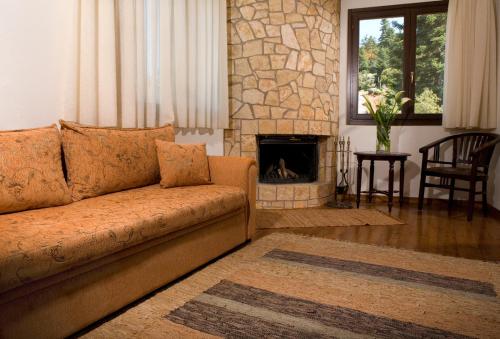 a living room with a couch and a fireplace at Vytina Mountain View Hotel in Vytina