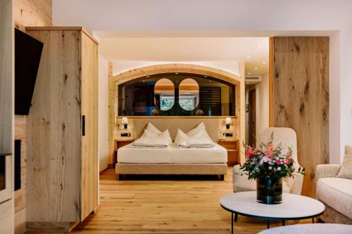 ein Schlafzimmer mit einem Bett und ein Wohnzimmer in der Unterkunft Hotel Klosterbräu in Seefeld in Tirol
