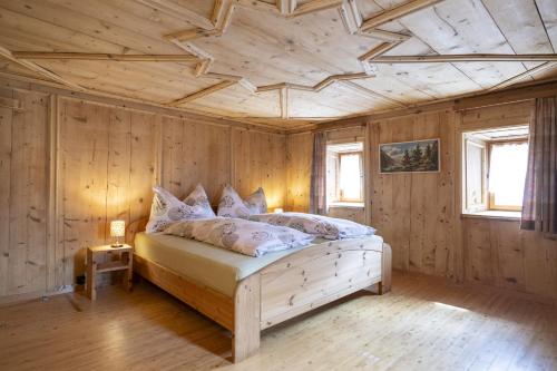 1 dormitorio con 1 cama con techo de madera en Chasa Broel Ferienhaus mitten in Ardez, en Ardez