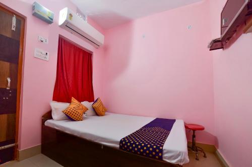 a bedroom with a bed with a red window at SPOT ON Hotel Vivek in Hājīpur