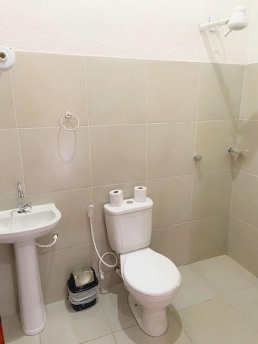 a bathroom with a toilet and a sink at Suite Apoena 4 in Pacoti