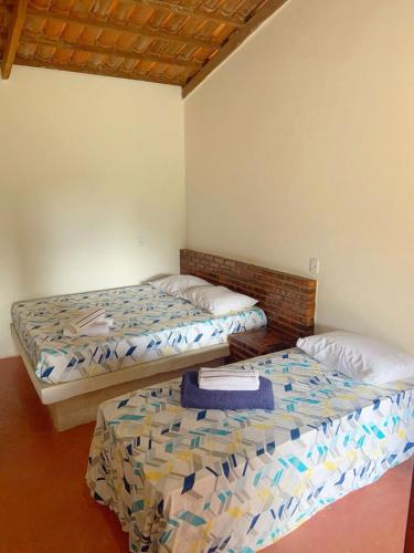 two beds sitting in a room with at Suite Apoena 4 in Pacoti