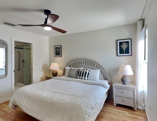 1 dormitorio con cama blanca y ventilador de techo en Casa Mar Y Palmera 202a en Clearwater Beach