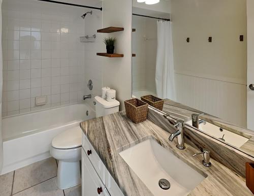 Baño blanco con lavabo y aseo en Casa Mar Y Palmera 202a en Clearwater Beach