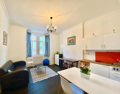 a kitchen and living room with a couch and a table at London SW Holiday Apartment - Free parking in London
