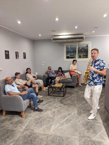 a man playing a saxophone in a room with people at Bedcoin Hostel in Hurghada