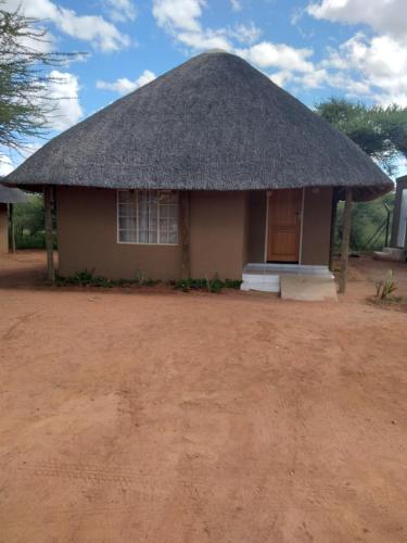 a small hut with a thatched roof at Pa Vula Hotels in Bokaa