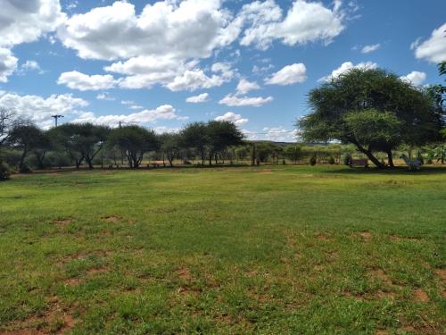 a field of grass with trees in the background at Pa Vula Hotels in Bokaa