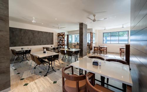 Un restaurante con mesas y sillas en una habitación. en Treebo Kaveri, en Nashik