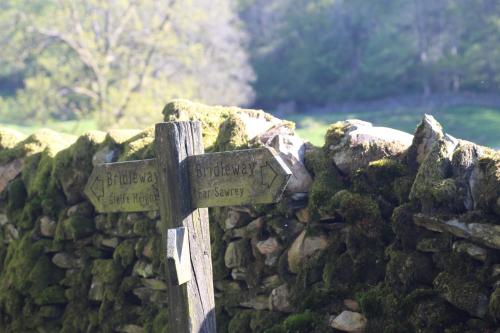 a stone wall with directions signs on it at The Cuckoo Brow Inn in Far Sawrey