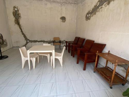 um quarto com uma mesa branca e cadeiras em Aeropark Residencial(1) em Maputo