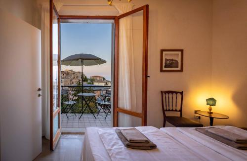a bedroom with a bed and a balcony with an umbrella at Casa Agello B&B in Ripatransone