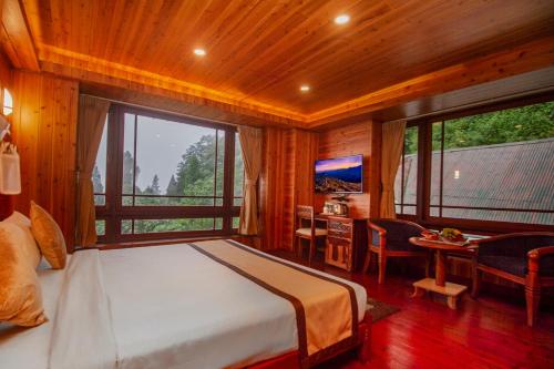 een slaapkamer met een bed, een bureau en een raam bij NRS Norling Retreat in Darjeeling