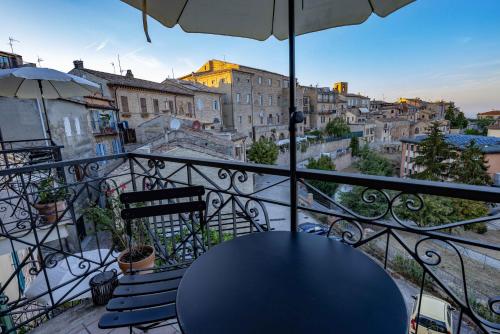 a balcony with a table and two chairs and an umbrella at Casa Agello B&B in Ripatransone