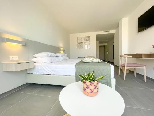 a bedroom with a bed and a table with a pot on it at Chez Maria Julia Boutique Hotel in Praia