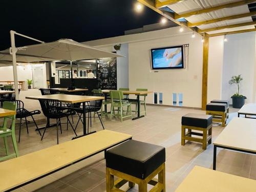 un restaurante con mesas y sillas y TV en la pared en Chez Maria Julia Boutique Hotel en Praia
