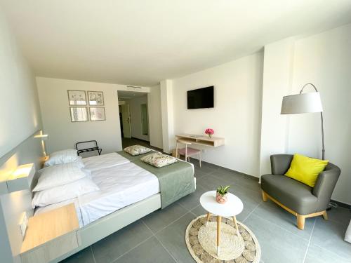 a bedroom with a large bed and a chair at Chez Maria Julia Boutique Hotel in Praia