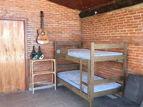 a room with two bunk beds and a guitar at Chalé Mirante, piscina, cachoeira, lago e vista espetacular in Alexânia