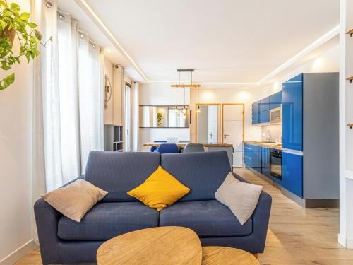un salon avec un canapé bleu et une cuisine dans l'établissement La Clé des Expos 