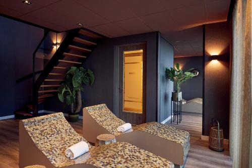 a waiting room with two chairs and a staircase at Van der Valk Hotel Leeuwarden in Leeuwarden