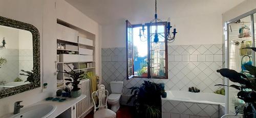 uma casa de banho com um lavatório, uma banheira e um espelho. em Maison d'Hôtes Archangels Home em Saint-Saëns
