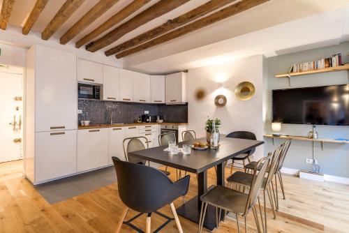 une cuisine et une salle à manger avec une table et des chaises dans l'établissement Sweett - Chevalier Saint Georges, à Paris