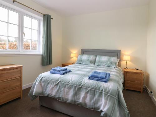 um quarto com uma cama com duas toalhas azuis em Bankhead of Lour Bungalow em Forfar