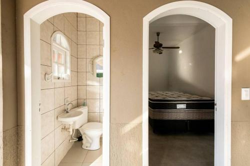 two pictures of a bathroom with a toilet and a sink at Casa Alto Padrão Piscina Aquecida e Sauna in Bertioga