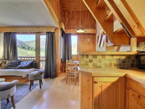 Il comprend une cuisine et un salon offrant une vue sur la montagne. dans l'établissement Duplex calme au pied des pistes, balcon et animaux acceptés - FR-1-455-232, à La Plagne Tarentaise
