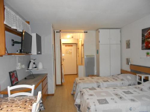 une chambre avec deux lits et une chambre avec une cuisine dans l'établissement Studio cosy à Brides-les-Bains - 4 pers, 28m², balcon, parking, wifi inclus - FR-1-512-270, à Brides-les-Bains