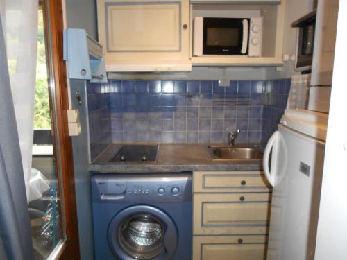 une petite cuisine avec une machine à laver et un évier dans l'établissement Studio cosy à Brides-les-Bains - 4 pers, 28m², balcon, parking, wifi inclus - FR-1-512-270, à Brides-les-Bains