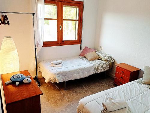 Habitación pequeña con cama y ventana en ATICO ESTUPENDO, en Calabardina