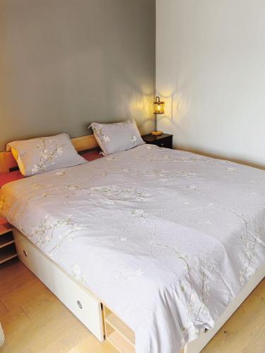 - une chambre avec un grand lit et des draps blancs dans l'établissement Paris La Defense - Courbevoie vue sur Seine, à Courbevoie
