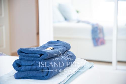 uma pilha de toalhas sentadas em cima de uma cama em Breathtaking Panoramic Views in Golf del Sur em San Miguel de Abona