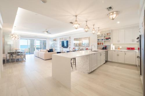 a kitchen and living room with white cabinets and a table at Beach Front Residence 107 located at The Ritz-Carlton in Upper Land
