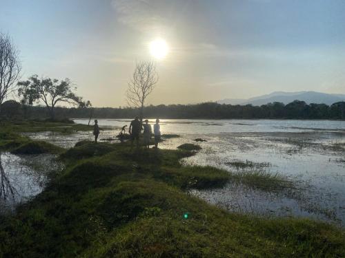 a group of people standing on the shore of a river at Moonshade Handapanagala in Monaragala
